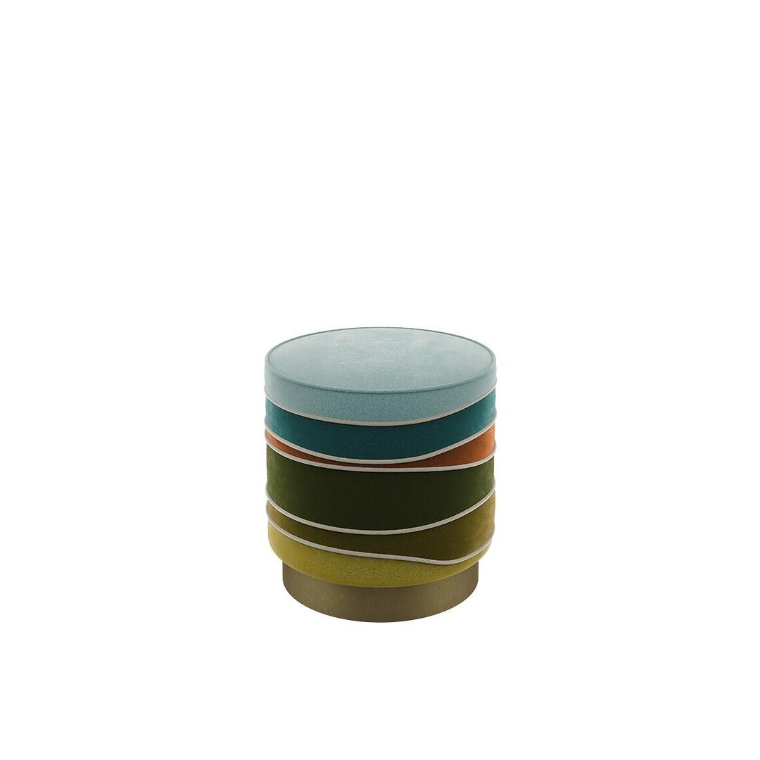 A three-quarter studio shot of the Charisse stool by Ottiu. The cylindrical stool features a layered "stacked" design upholstered in multi-colored velvet, including light blue, teal, burnt orange, forest green, and mustard yellow. Each undulating layer is defined by light-colored velvet piping, and the piece is supported by a circular brushed brass base.