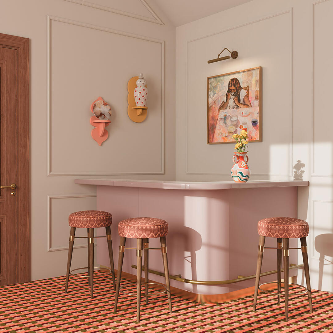 3 Louis bar stools upholstered in a pink heart-patterned fabric, featuring smoked walnut legs with brass details, placed in a stylish home bar setting with a patterned carpet.