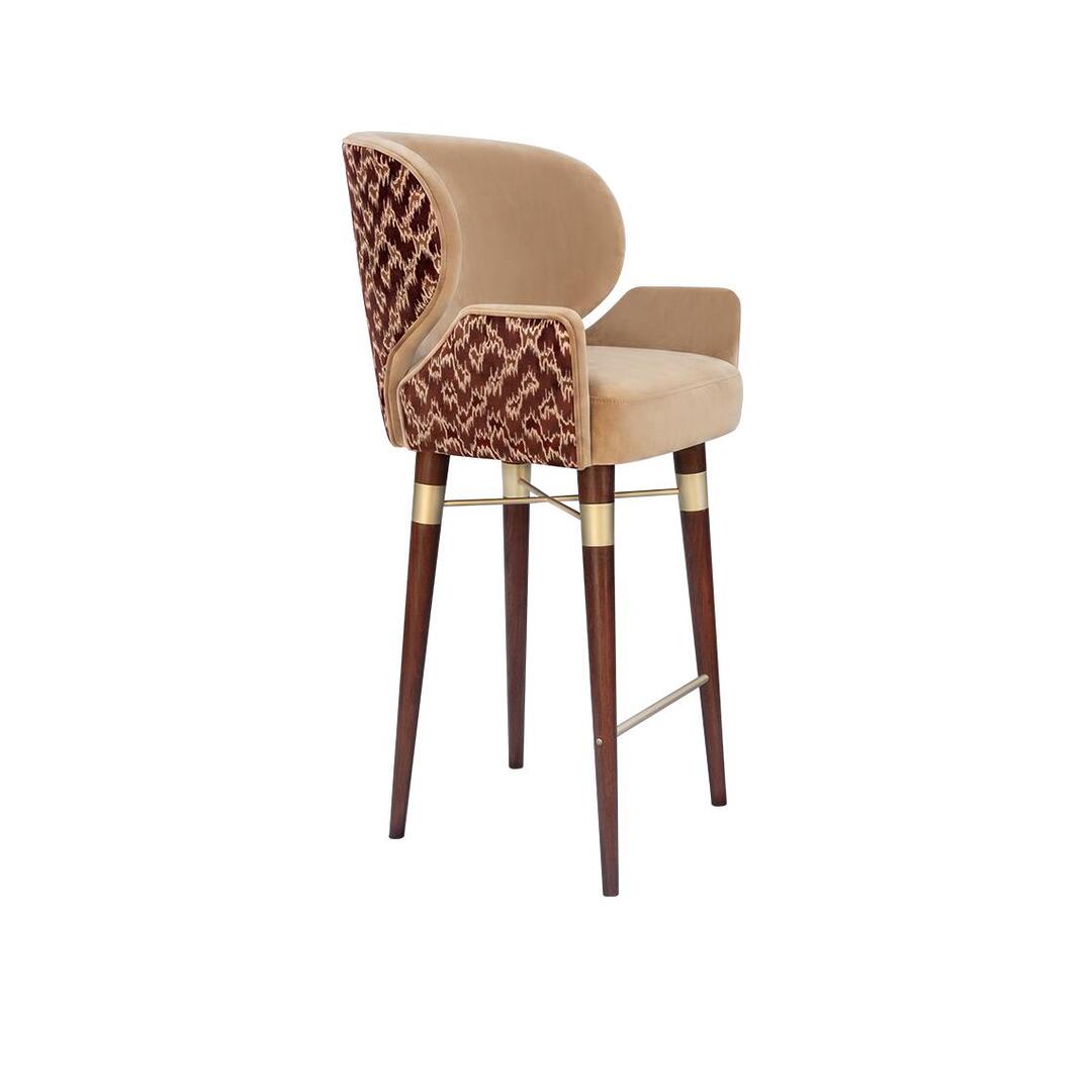 For image_3.png: A side view of the Ottiu Louis I bar chair, upholstered in a solid beige fabric on the interior and seat. The patterned fabric in dark red is featured on the side and back. The dark wood legs have brushed brass details.