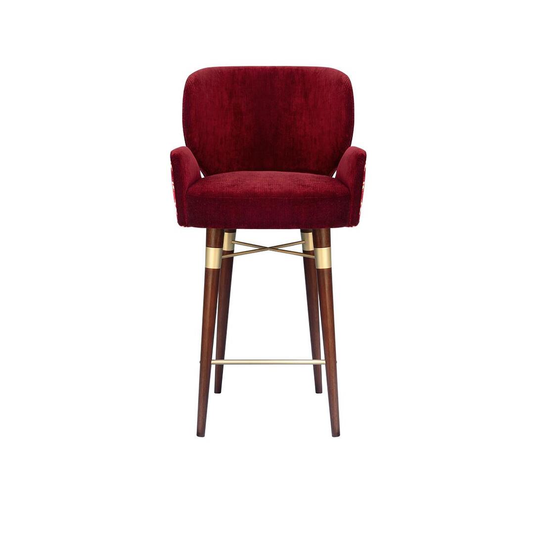 A front view of the Ottiu Louis I bar chair, featuring a solid red velvet seat and interior. The tall dark wood legs are joined by brushed brass accents and a footrest.