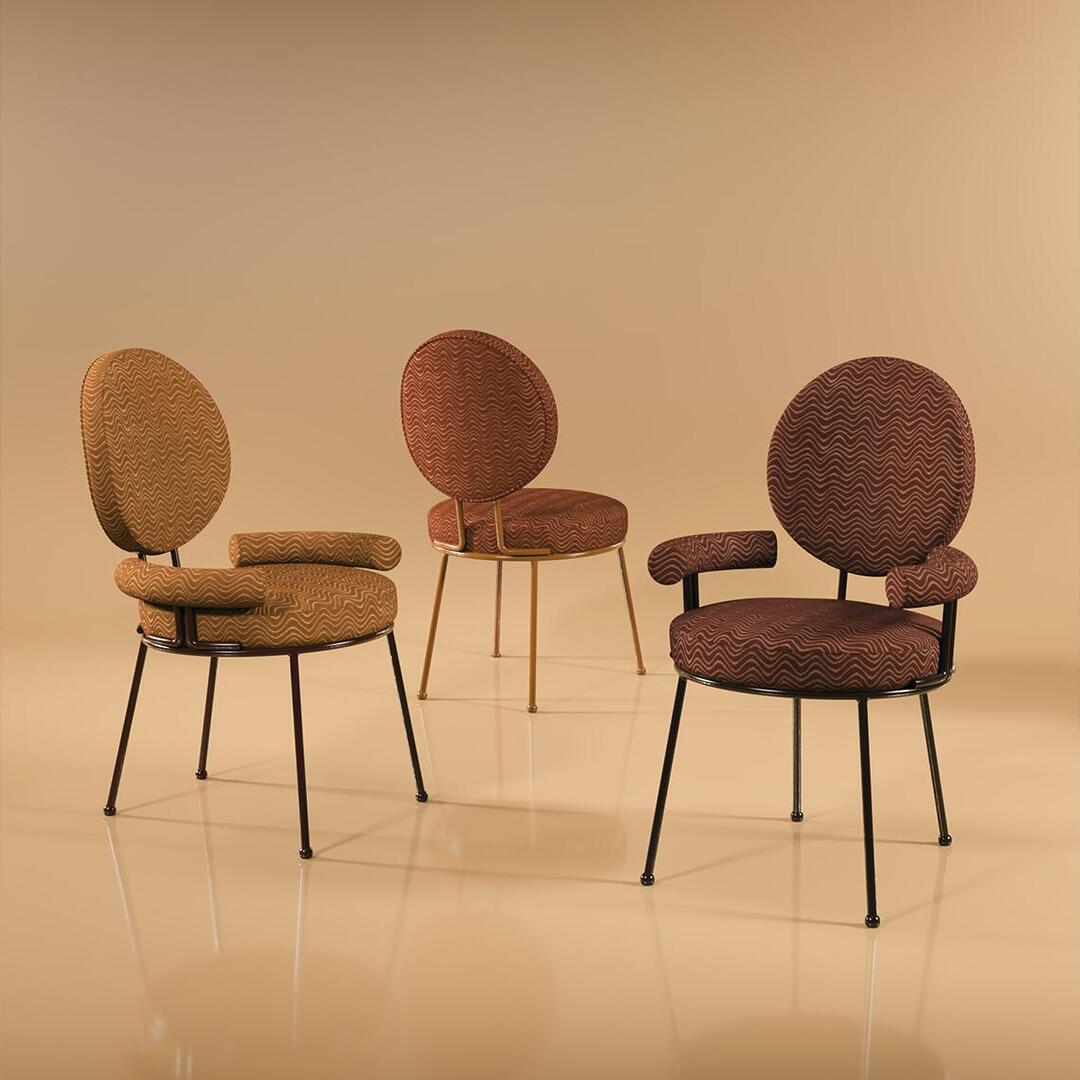 Brigid dining chair collection by Ottiu, featuring three upholstered dining chairs set against a soft yellow background, upholstered in Kirkby Design fabrics: K5365-02 Scroll Tobacco and K5365-04 Scroll Dark Chocolate.