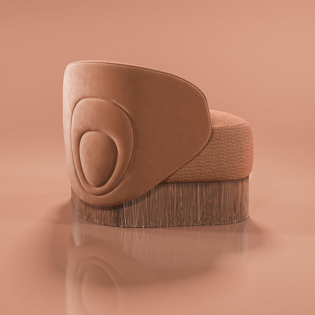 Doris armchair shown from a 45º back angle against a peach background. The piece showcases a lavish composition, exquisitely hand-upholstered in sumptuous orange velvet and elegantly draped with cascading fringes that exude grandeur. Finished in Dedar fabrics: Ripley and Plushy.