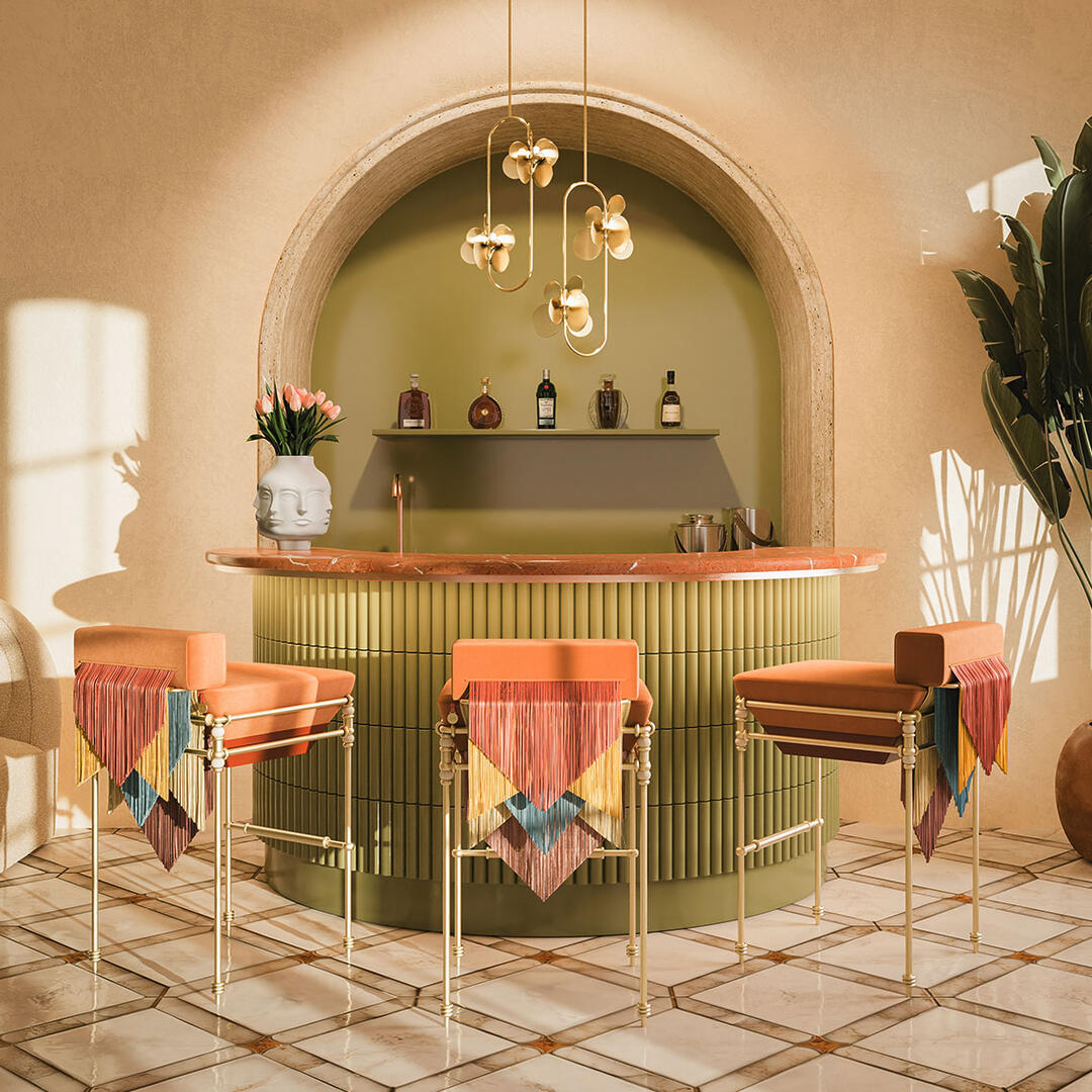 Fringes Flow in this Three Seraphine bar chairs in a bar setting with warm tones. The chairs feature fringes in yellow, blue, and soft red, and are upholstered in orange. The setting includes two Hera suspension lamps in brass.
