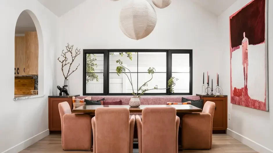 banquette-seating-Hollis-Jordyn-Design Built-in banquette seating with upholstered cushions along a dining nook, paired with a wooden table and accent pillows, creating a cozy and space-saving dining area.