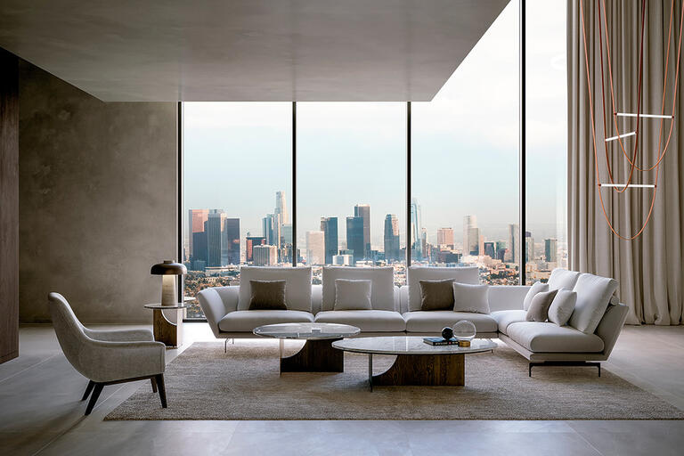Elegant living room featuring modern sectional sofas in neutral tones, paired with minimalist tables and warm lighting.