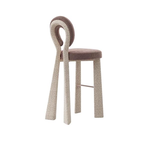 Three-quarter rear view of the Mary Bar Chair featuring a sculptural open-back design. The frame is upholstered in a textured cream bouclé, while the circular backrest and seat are dressed in a dusty-rose velvet with a subtle geometric pattern.