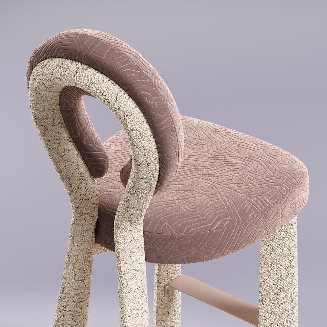 A close-up, high-angle shot of the Mary Bar Chair’s backrest and seat. This detail highlights the contrast between the plush, mauve velvet with its intricate geometric pattern and the highly textured, cream-colored bouclé that wraps around the sculptural frame.