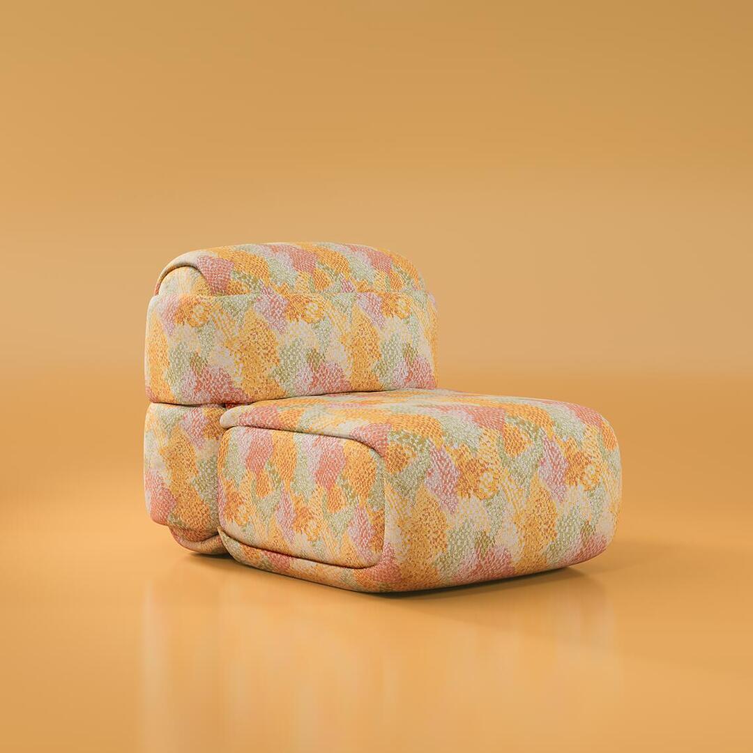 The Elsa Module is a modular seating component with a rounded, pillowy silhouette. It features a voluminous backrest and thick seat cushion, entirel upholstered in a multi-colored textured fabric with a geometric mosaic pattern in warm yellow, coral, peach, and sage green tones. This single unit is designed to be paired with other modules to create a larger sofa, or it can stand alone as a sculptural club chair. It rests directly on the floor with a clean, low-profile base.