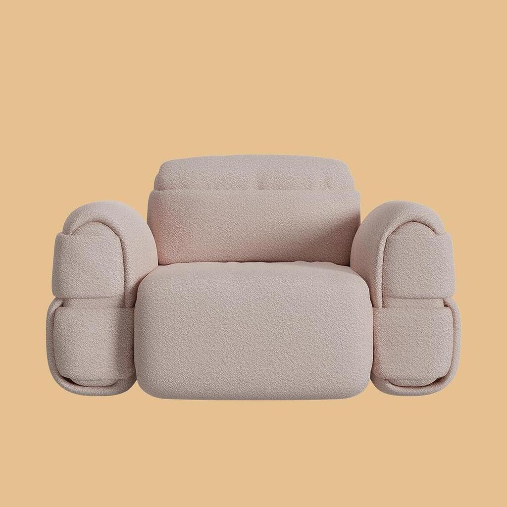 The Elsa Modular Armchair, viewed from the front. Featuring a voluminous, pod-like silhouette with a thick seat, curved back, and massive segmented armrests, this piece is fully upholstered in a soft, light blush-pink textured bouclé fabric.