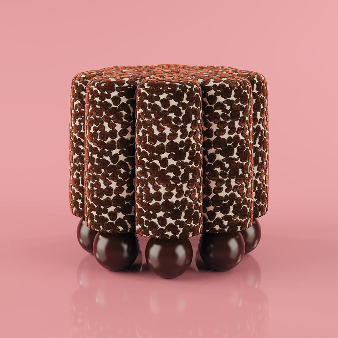 Front view, lifestyle shot of the Myrna Stool, highlighting the high-gloss spherical feet and the luxurious texture of the Misia Niki fabric against a soft pink background.