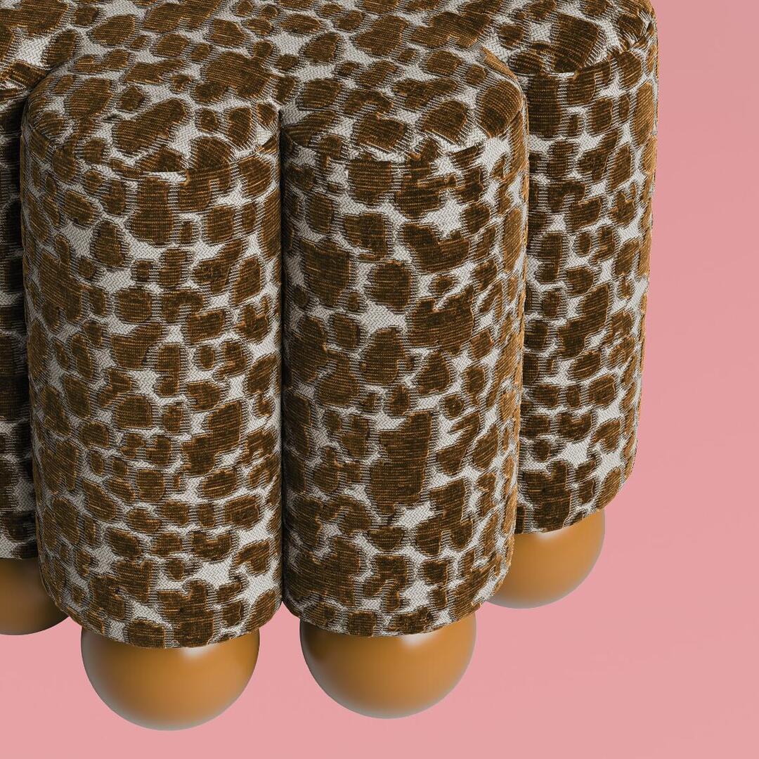 Macro detail shot of the Myrna Stool, focusing on the complex pattern of the Misia Niki velvet upholstery on the vertical tubes, and the light brown glossy sphere base, against a pink background.