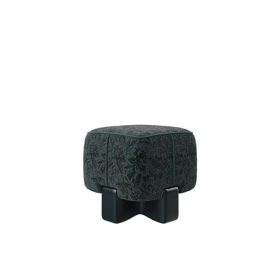 A front view of the Pola Stool in a moody forest green velvet, showcasing the intricate floral textures and the sturdy, dark lacquered geometric base.