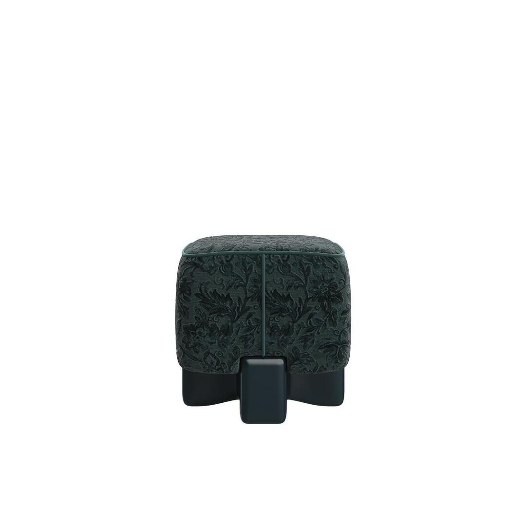 A direct side view of the Pola Stool in forest green, illustrating the sculptural silhouette and the theatrical balance between the romantic upholstery and the rigid base.