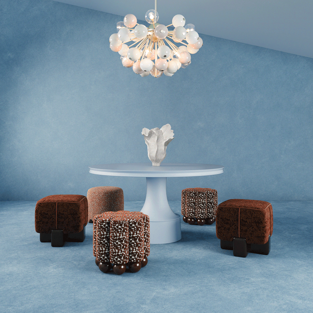 An animated interior scene featuring the Pola Stool in terracotta velvet, the pleated Myrna Stool, and the textured Bette Stool, all arranged around a white pedestal table in a blue-toned modern room.