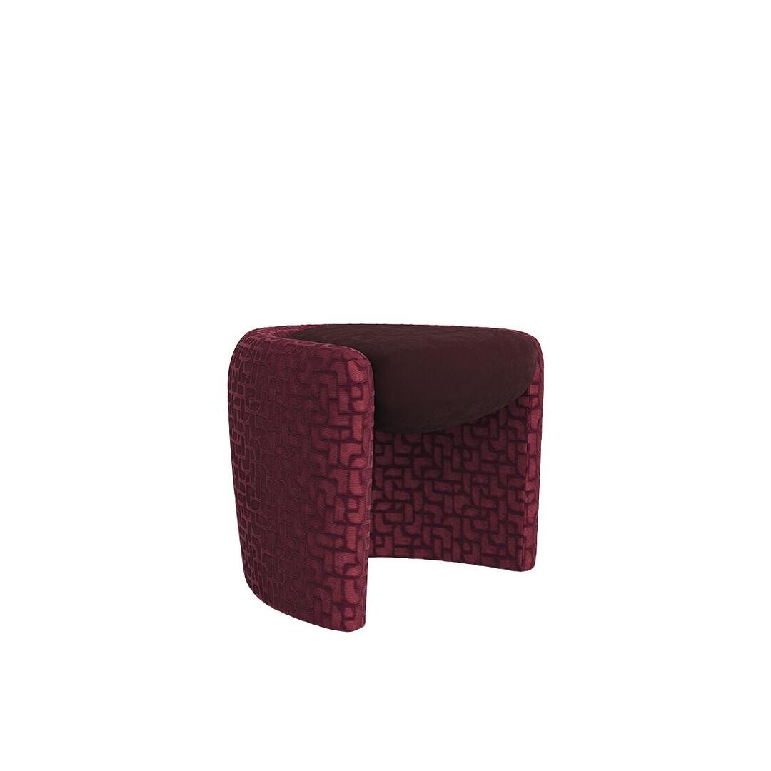 Three-quarter view of the Grace Stool by Ottiu in a deep burgundy hue, displaying the contrast between its smooth suede seat cushion and the richly textured geometric patterned velvet upholstery on its curved frame.