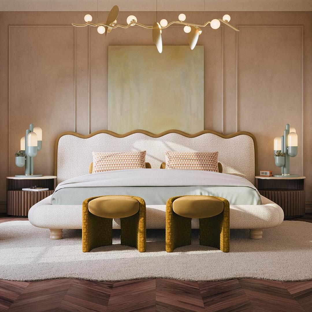 Pair of Grace Stools by Ottiu in mustard yellow velvet and suede, positioned at the foot of a modern upholstered bed in a luxury, warm-toned bedroom with neutral decor.