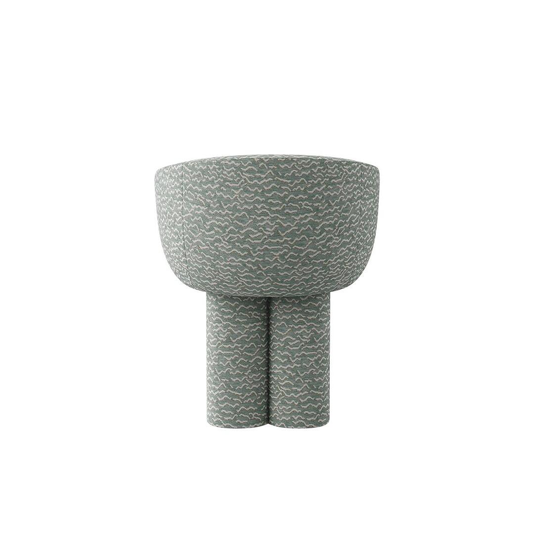 A rear view of the Mae Dining Chair, fully upholstered in the "Pierre Frey - Le chant des dunes - Aqua" fabric. The image focuses on the continuous curved backrest and the singular, sturdy leg column from the back.