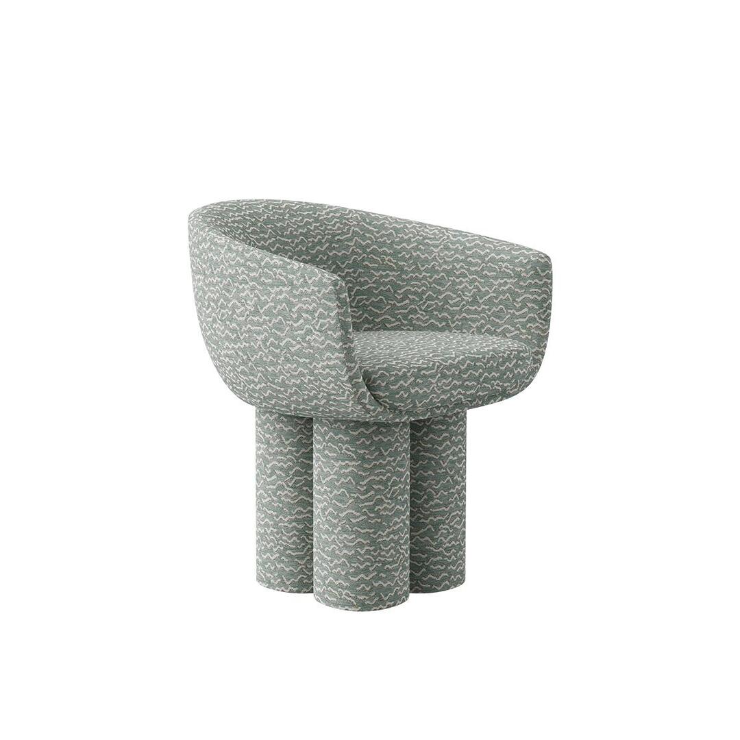 A three-quarter front view of the Mae Dining Chair, demonstrating its curved shape and the plush, rounded seat. The "Pierre Frey - Le chant des dunes - Aqua" fabric pattern is clearly visible across the entire structure.