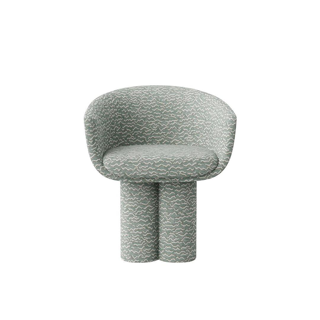 A straight-on back view of the Mae swivel Dining Chair, showcasing the smooth curve of the upholstered backrest and the solid, wrapped leg from behind. The piece is entirely covered in the textured "Pierre Frey - Le chant des dunes - Aqua" fabric.