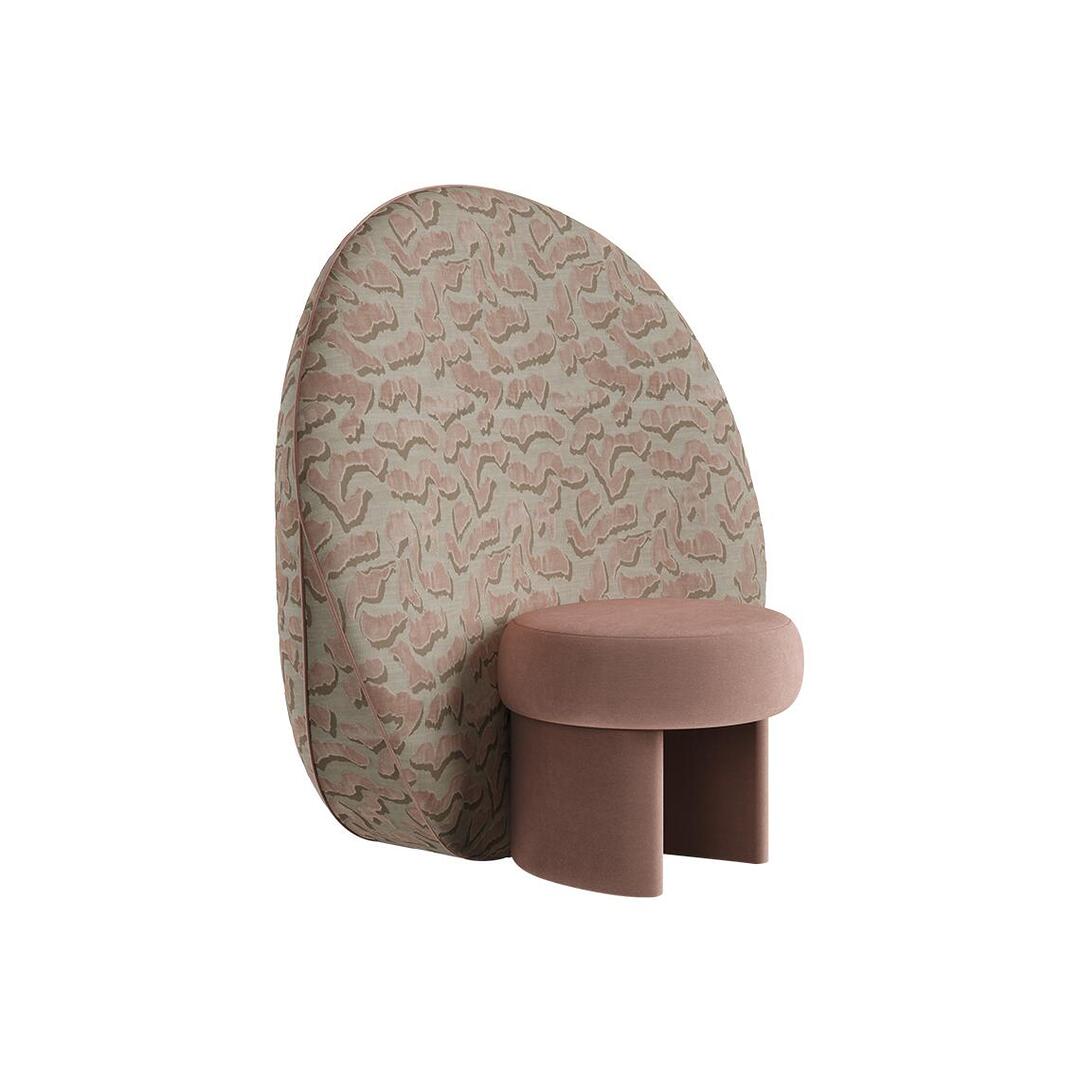 Three-quarter front view of the Solène Armchair by Ottiu in the pink colorway. The perspective emphasizes the depth of the cylindrical pink velvet seat and the impressive scale of the thick, coin-shaped back panel covered in an organic pink and beige wavy pattern.