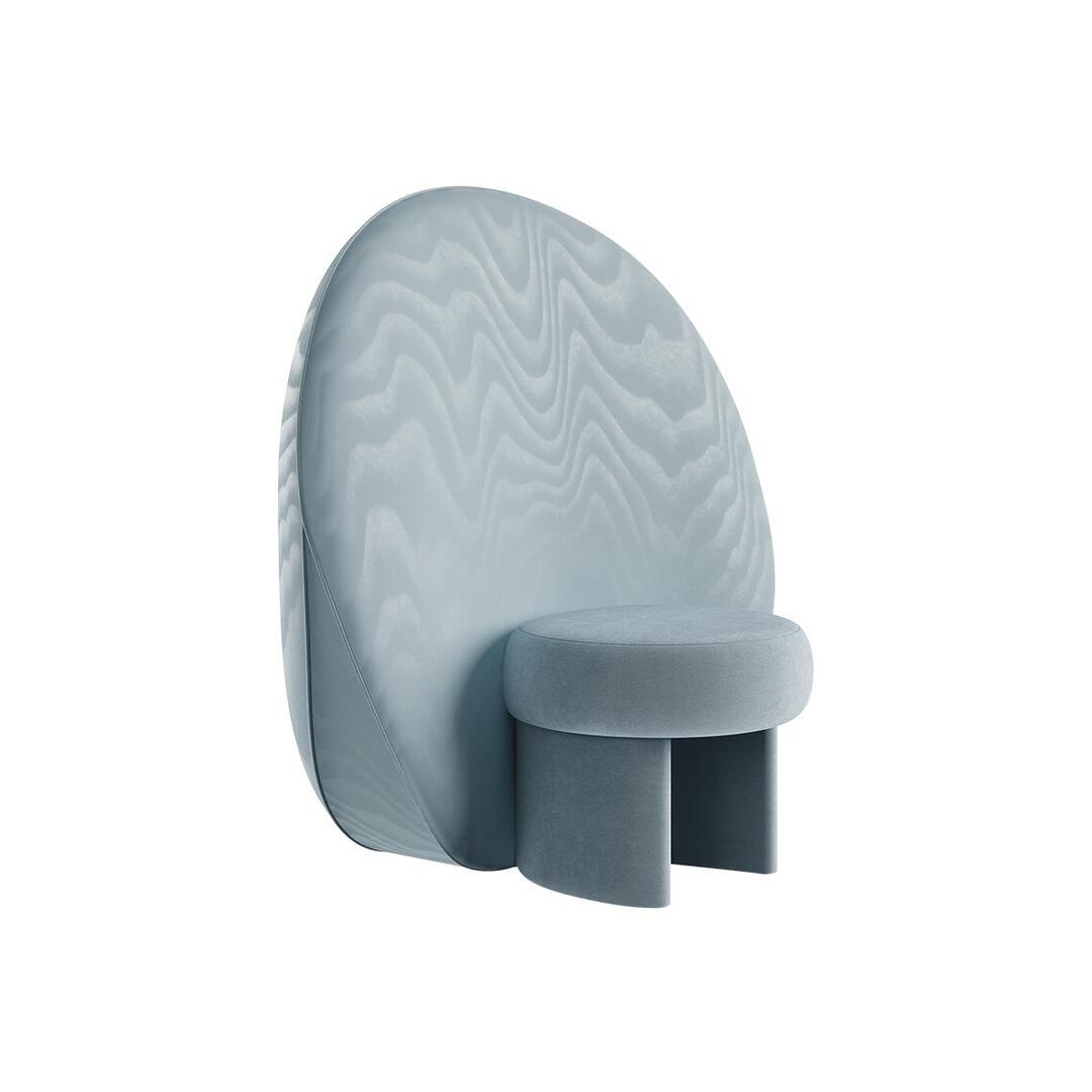 Three-quarter perspective view of the ice-blue Solène Armchair, highlighting the depth of the cushioned, sculptural round seat and the clean, modern profile of its oversized circular backrest.