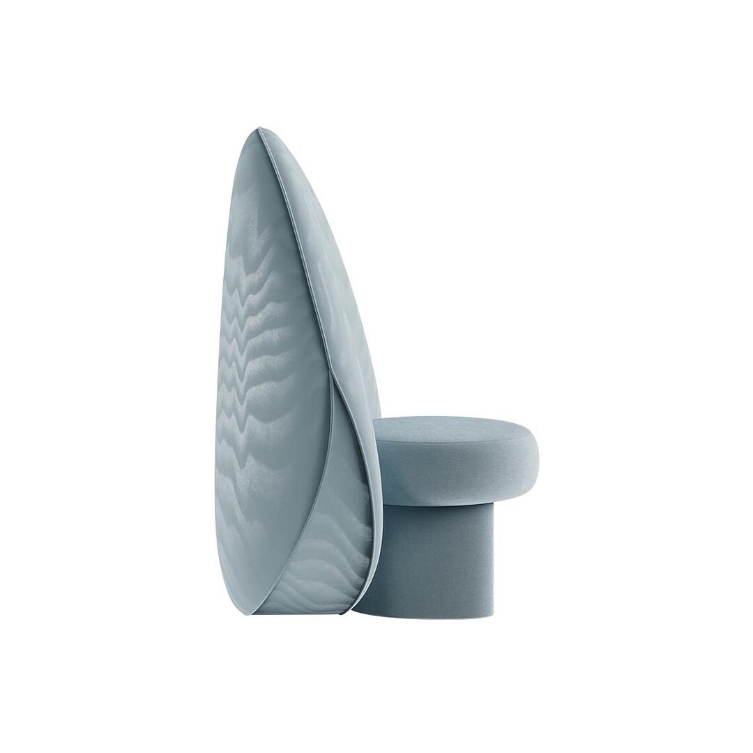 Side profile view of the ice-blue Solène Armchair, showing the sleek, vertical silhouette of the large circular backrest and the distinct, blocky shape of the velvet upholstered seat and legs.