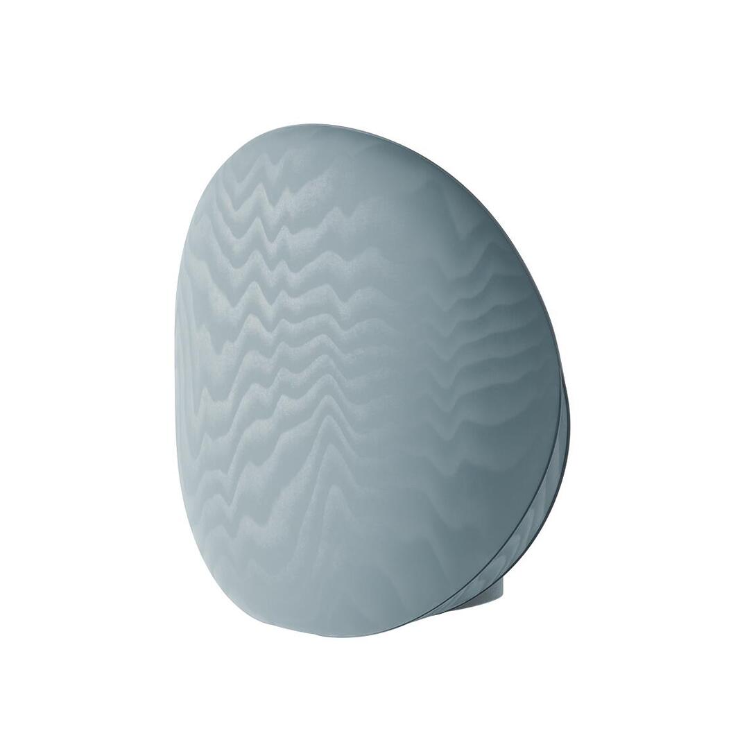 ear three-quarter view of the ice-blue Solène Armchair, focusing on the expansive, smooth surface of the circular backrest covered in the wavy patterned Moiré Libre fabric.