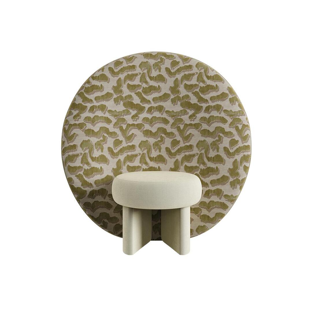 Front view of the Solène Armchair by Ottiu, showcasing a minimalist round seat cushion and intersecting base upholstered in cream-colored cotton velvet. The large, dominant circular backdrop features a fluid, abstract pattern in olive green and neutral beige velvet jacquard.