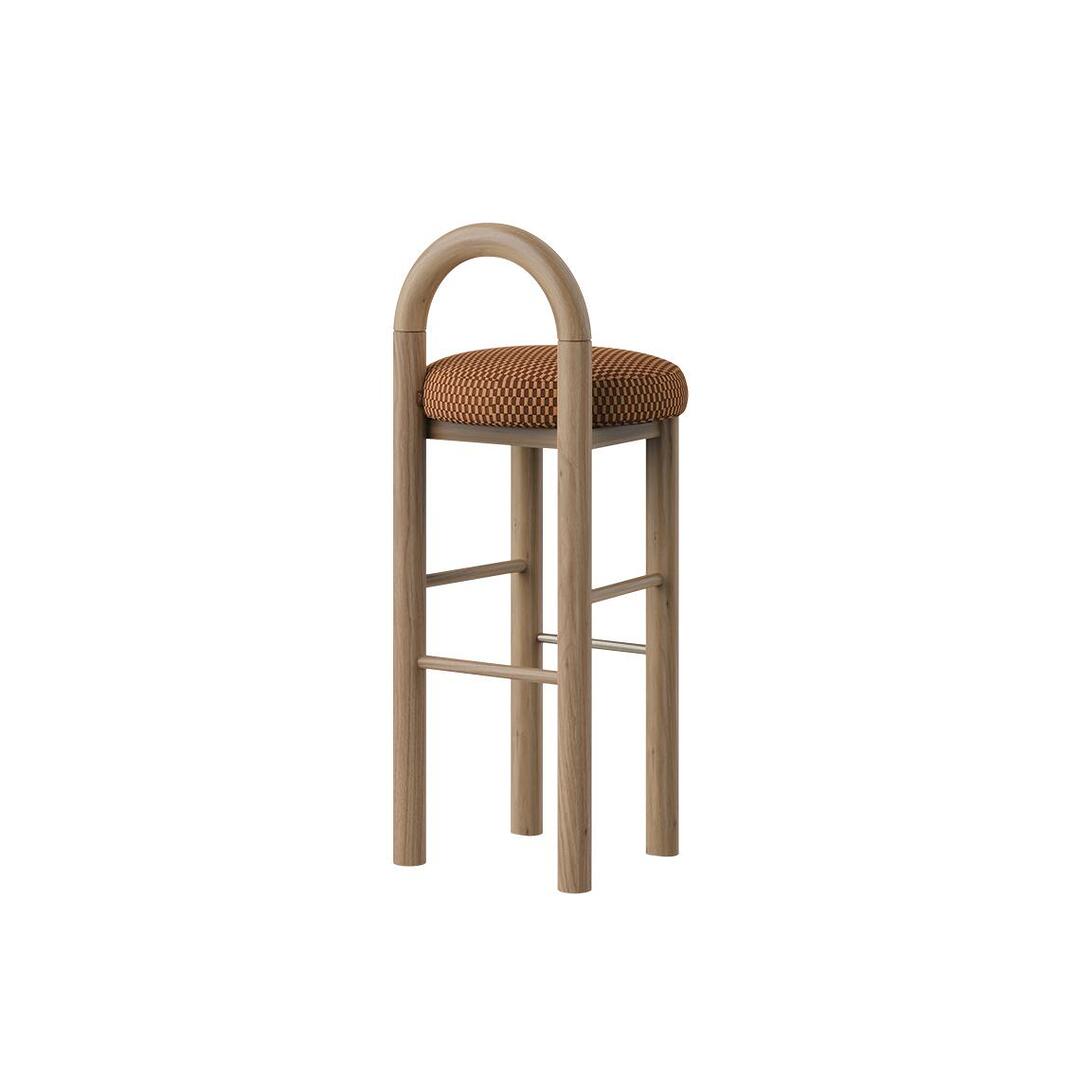 Side profile view of the Ann Bar Chair without fringes, highlighting the natural wood structure, arched backrest, decorative weave upholstered seat cushion, and stainless steel footrests.