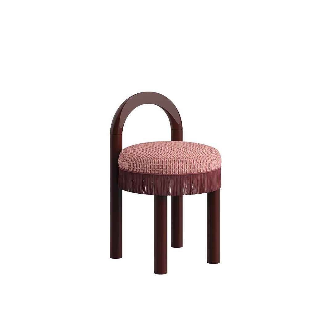 Three-quarter view of the Ann dining chair in a dark lacquered wood finish, with a textured red-patterned woven fabric seat and matching fringe.