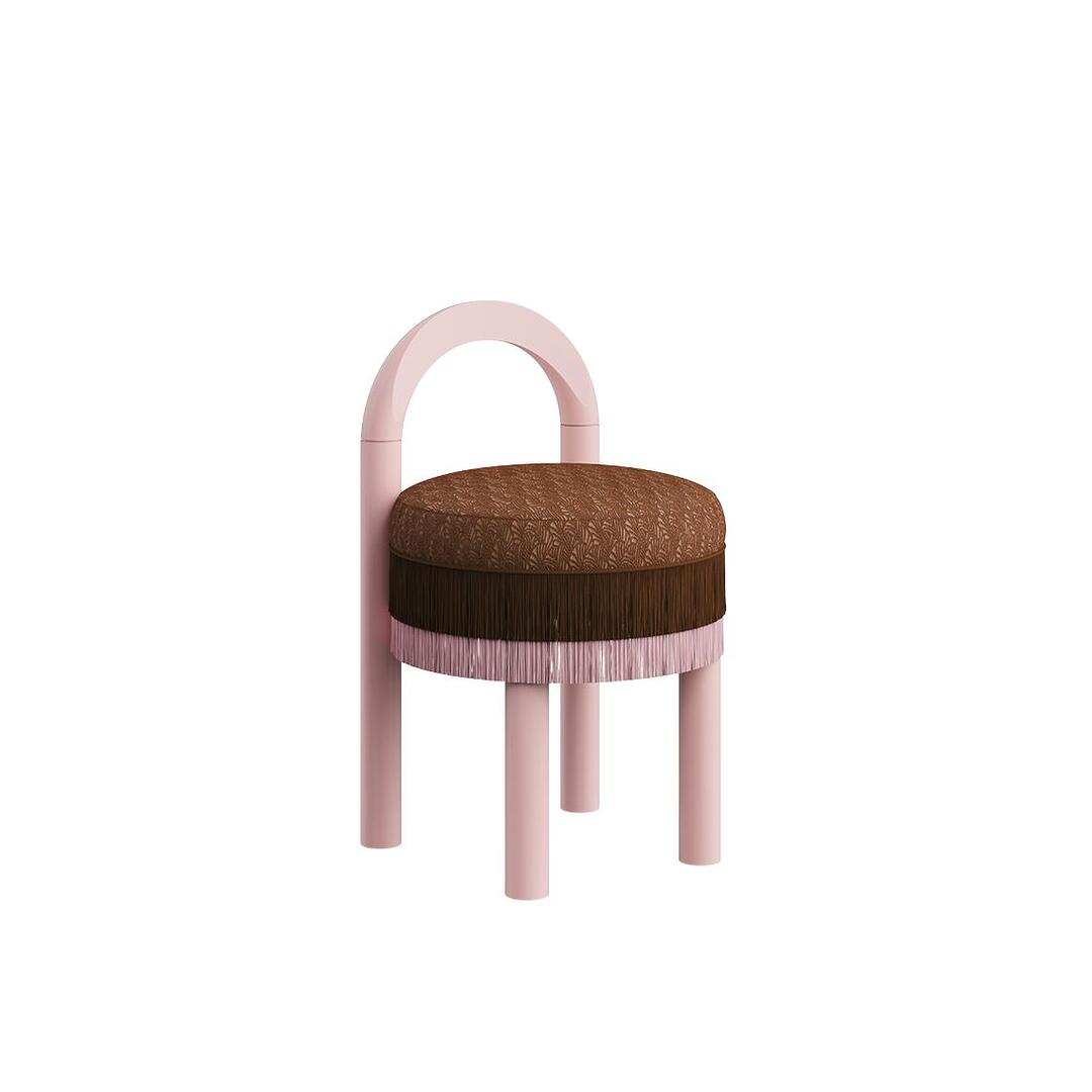 Three-quarter view of the Ann dining chair featuring a light pink lacquered wood frame, textured brown fabric seat, and a two-layer fringe trim.