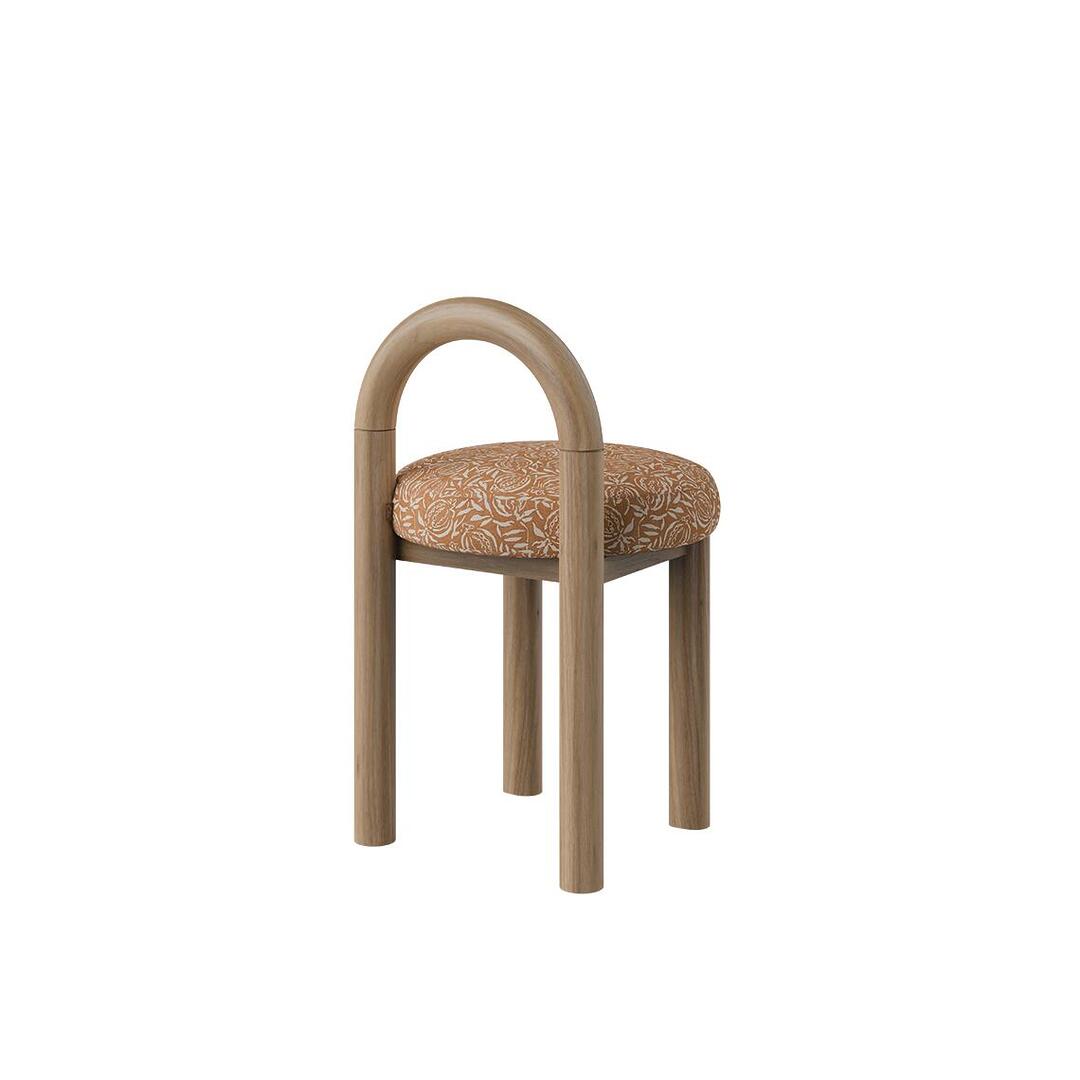 Three-quarter view of the Ann dining chair version without fringes, displaying an arched natural wood structure and a floral decorative weave seat.